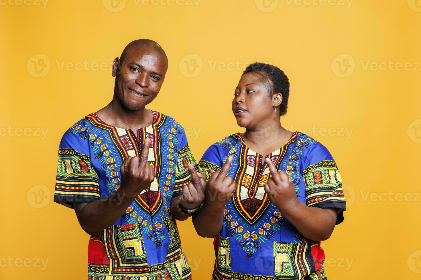 grossier africain américain couple montrant milieu doigt geste et à la recherche à caméra avec en colère expression. furieux homme et femme démontrant offensive et mal comportement studio portrait photo