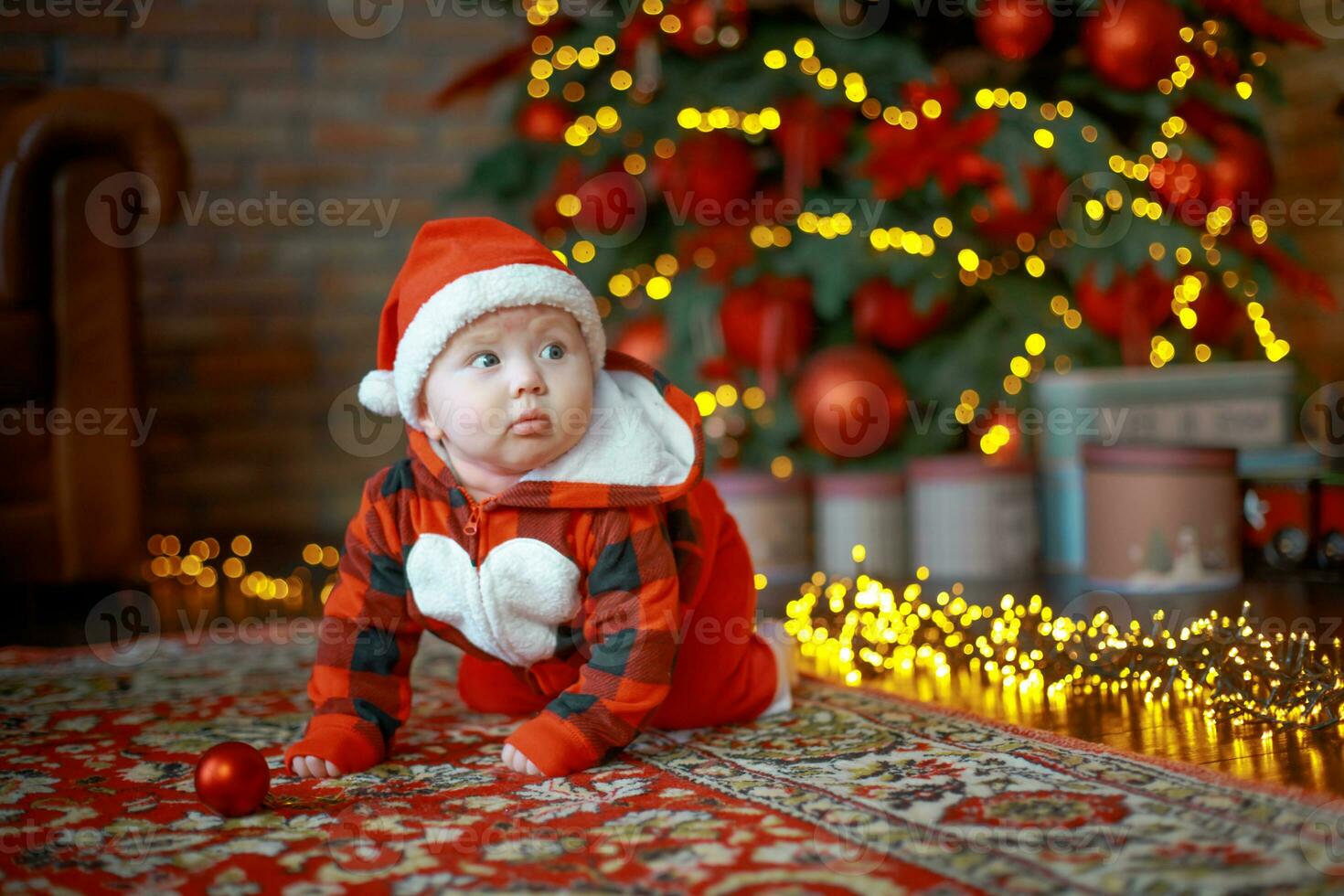 peu content fille de 6 mois rampe près une Nouveau année arbre sur Noël veille. enfant dans Père Noël claus costume près lumineux guirlandes. content Nouveau année 2020 concept photo