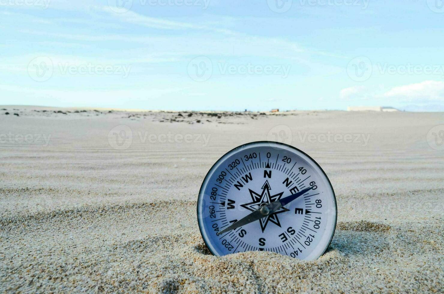 une boussole est séance dans le le sable sur une plage photo