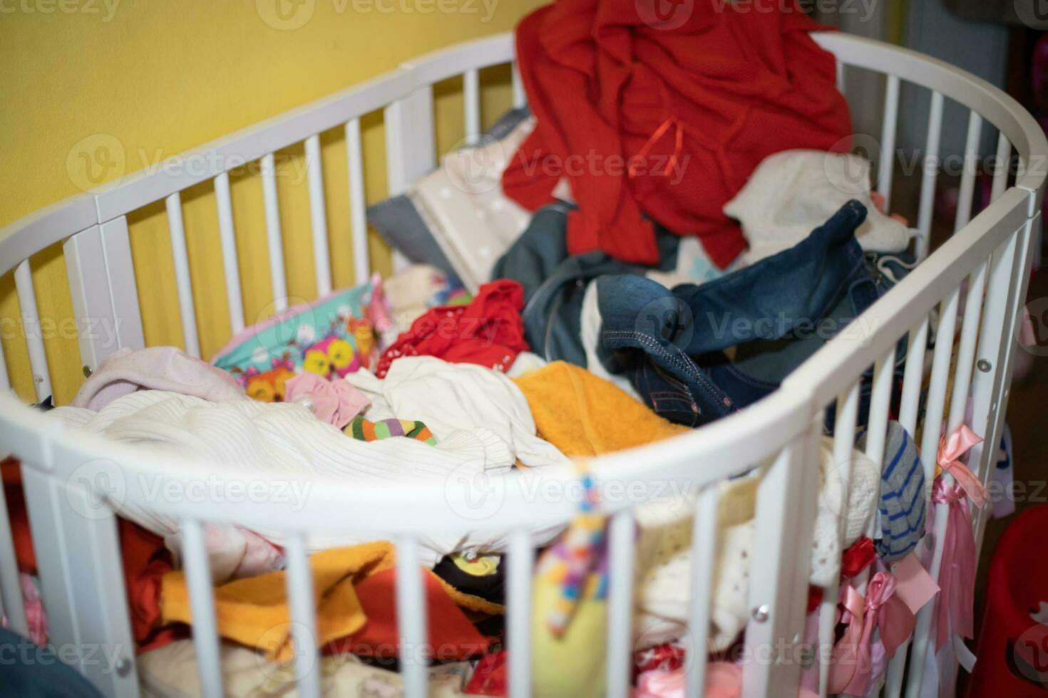 en utilisant lit bébé est ne pas pour prévu but. bouquet de des choses vidé dans de bébé copier. enfant Est-ce que ne pas sommeil dans berceau. mal avec vêtements photo