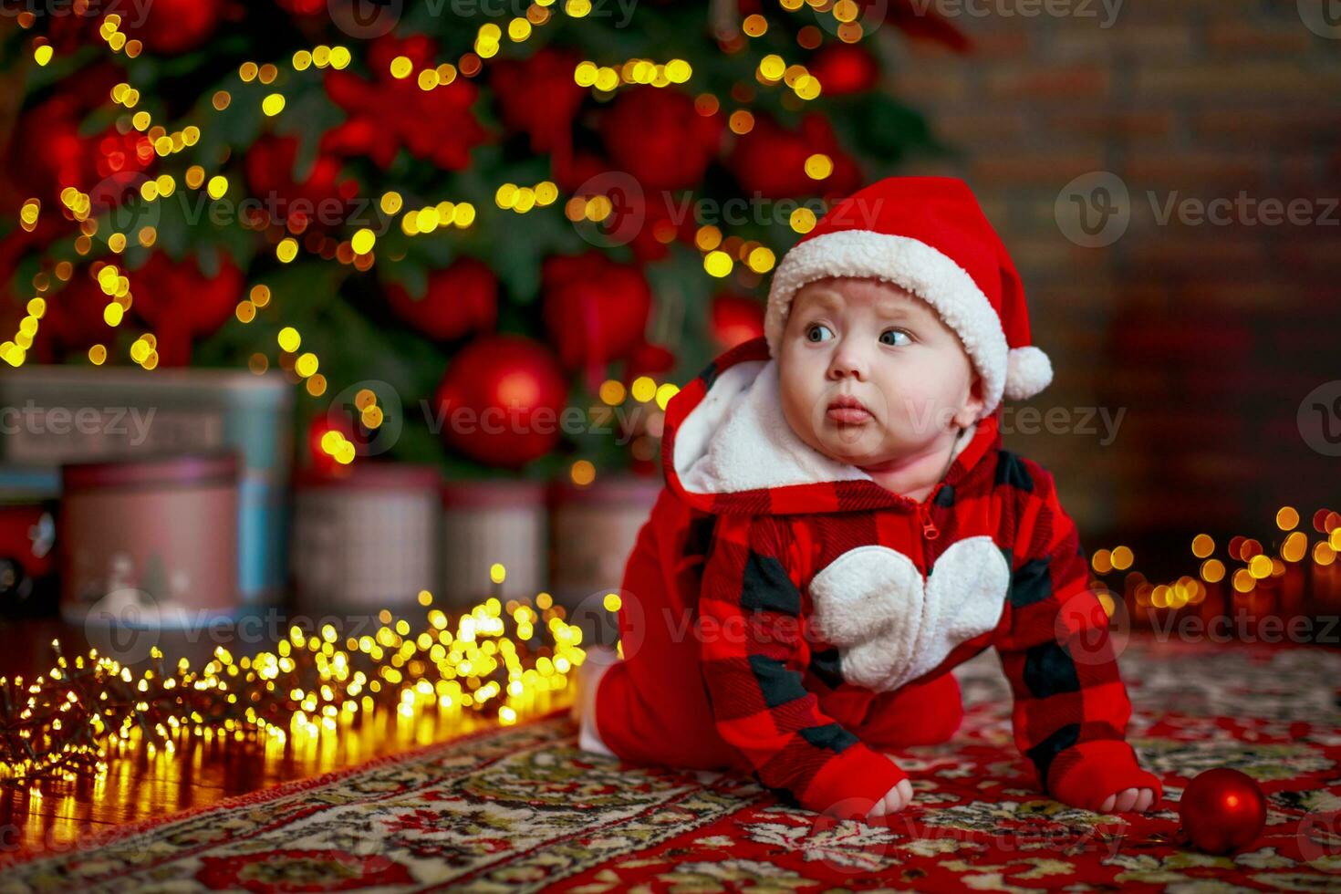 peu six mois vieux bébé habillé comme Père Noël claus. Contexte pour Noël carte. le enfant regards vers le bas à le endroit pour une inscription. photo