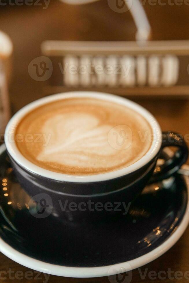 café tasse avec une cœur modèle dans une bleu tasse sur une en bois Contexte. une signe avec le une inscription - réservé. photo