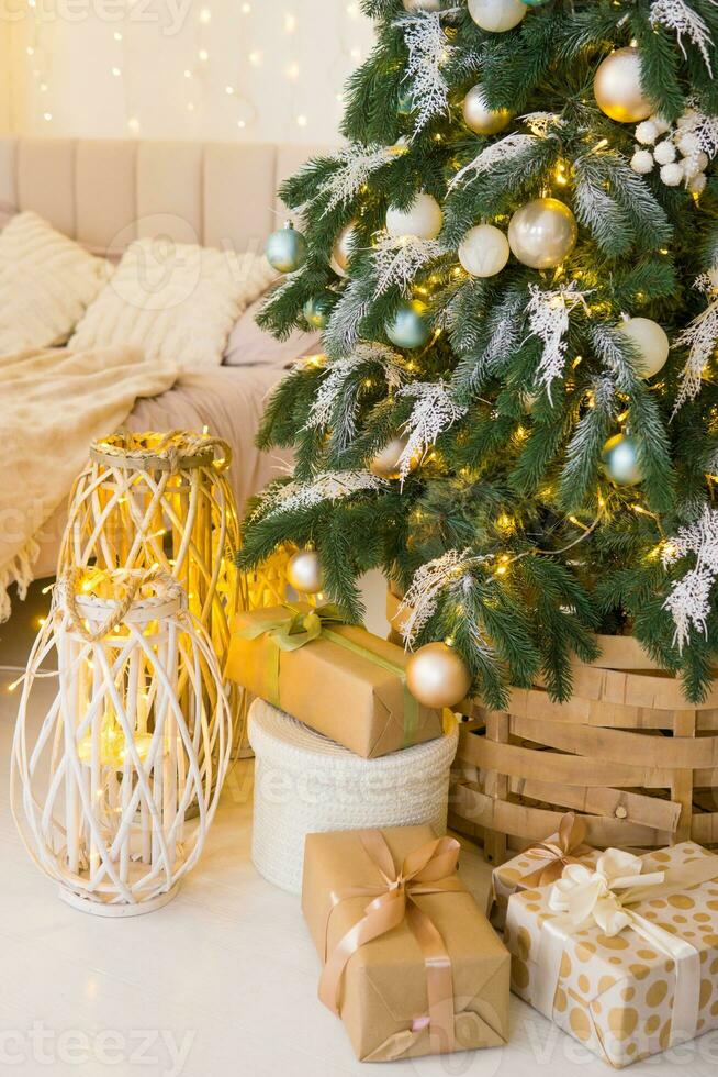 designer Noël arbre décoration avec lumière décorations. le concept de célébrer Nouveau année et Noël. cadeaux dans artisanat emballage en dessous de le Noël arbre. photo