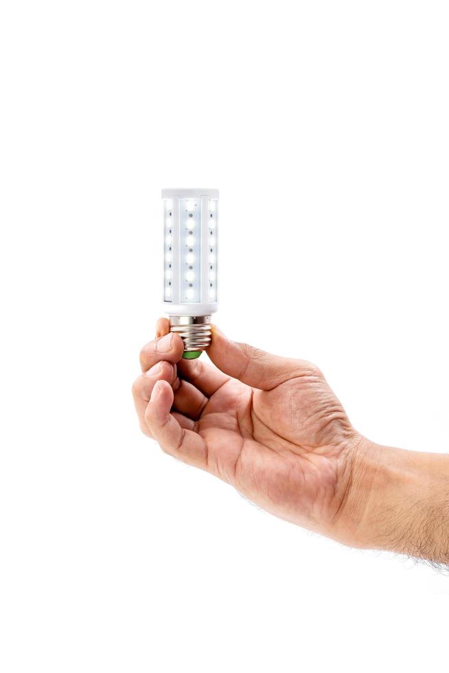 main humaine tenant une ampoule LED isolée sur fond blanc. photo