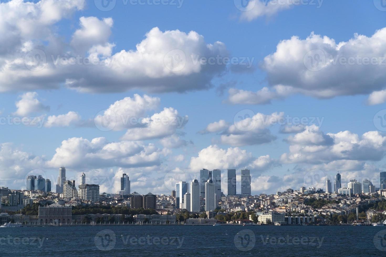 le palais de dolmabahce et les gratte-ciel modernes avec un magnifique paysage nuageux sur le bosphore d'istanbul photo