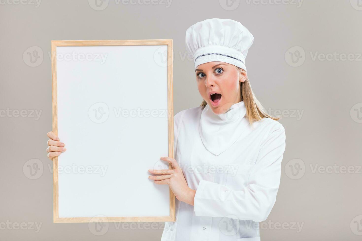 portrait de excité et surpris femelle chef en portant tableau blanc photo