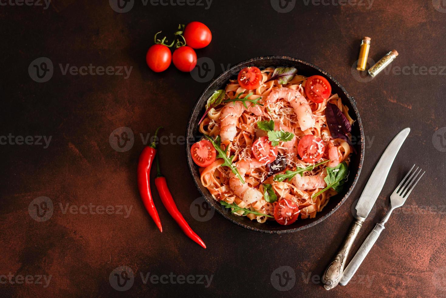 pâtes savoureuses aux crevettes et tomates sur une poêle à frire photo