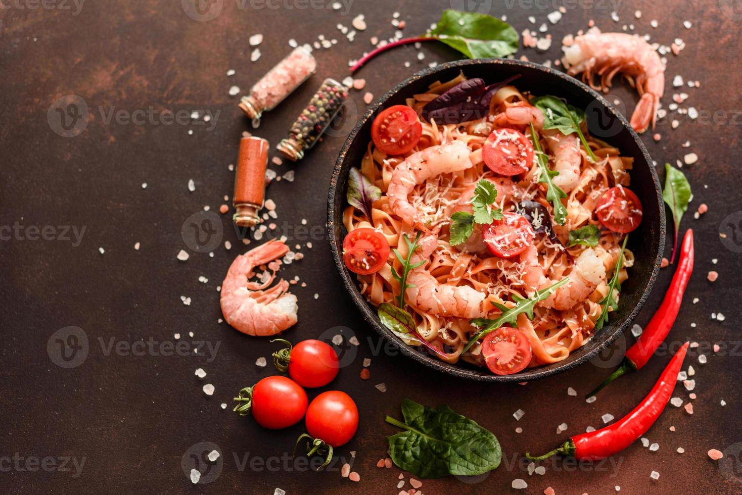 pâtes savoureuses aux crevettes et tomates sur une poêle à frire photo