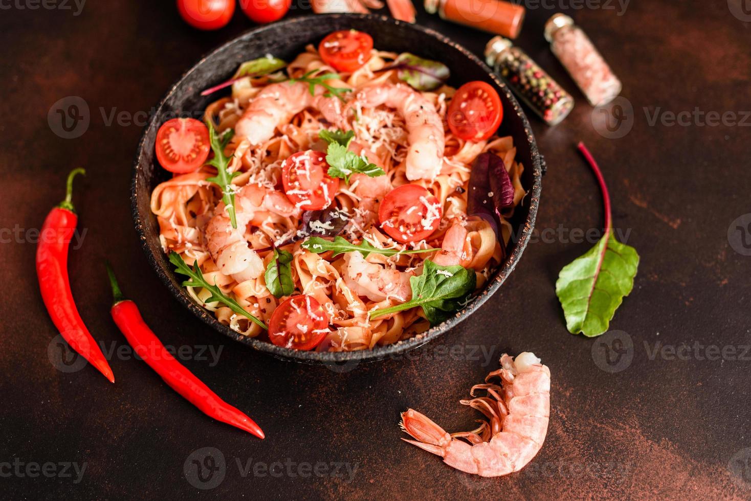 pâtes savoureuses aux crevettes et tomates sur une poêle à frire photo