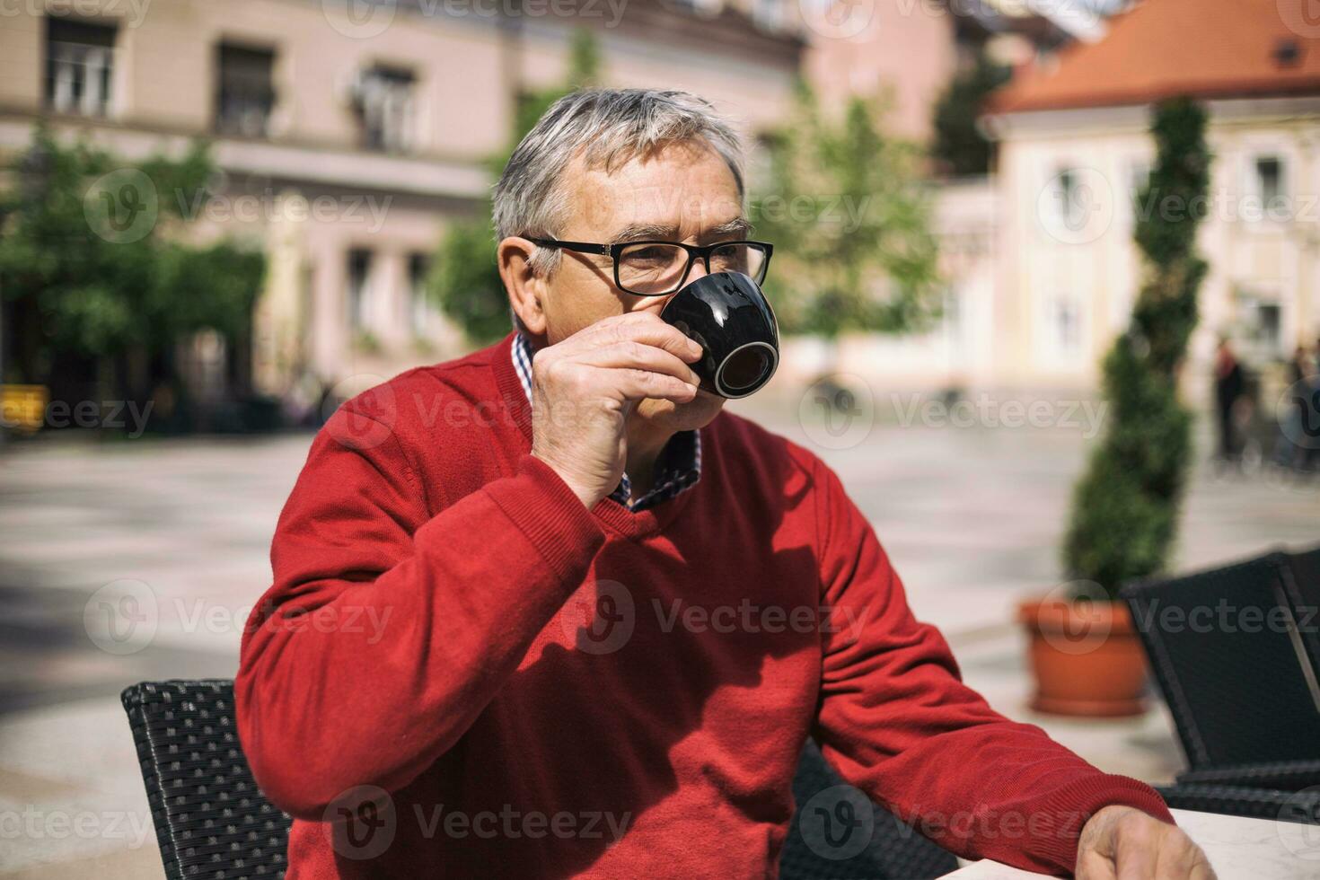 Sénior homme jouit en buvant café à le bar photo