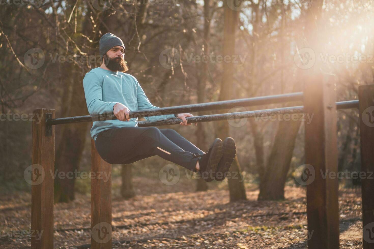 homme jouit exercice pousser UPS sur parallèle bars dans le parc. photo