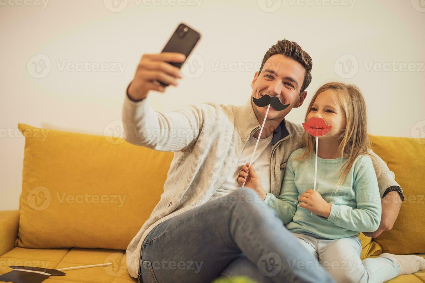 père et fille prise selfie tandis que elles ou ils ayant amusement avec fête accessoires à leur Accueil photo