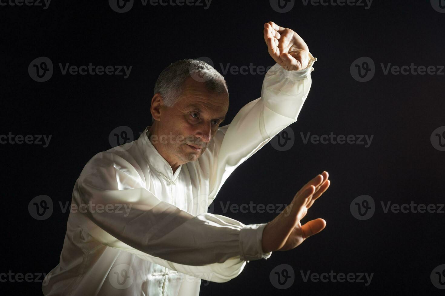 Sénior homme jouit exercice tai chi intérieur photo