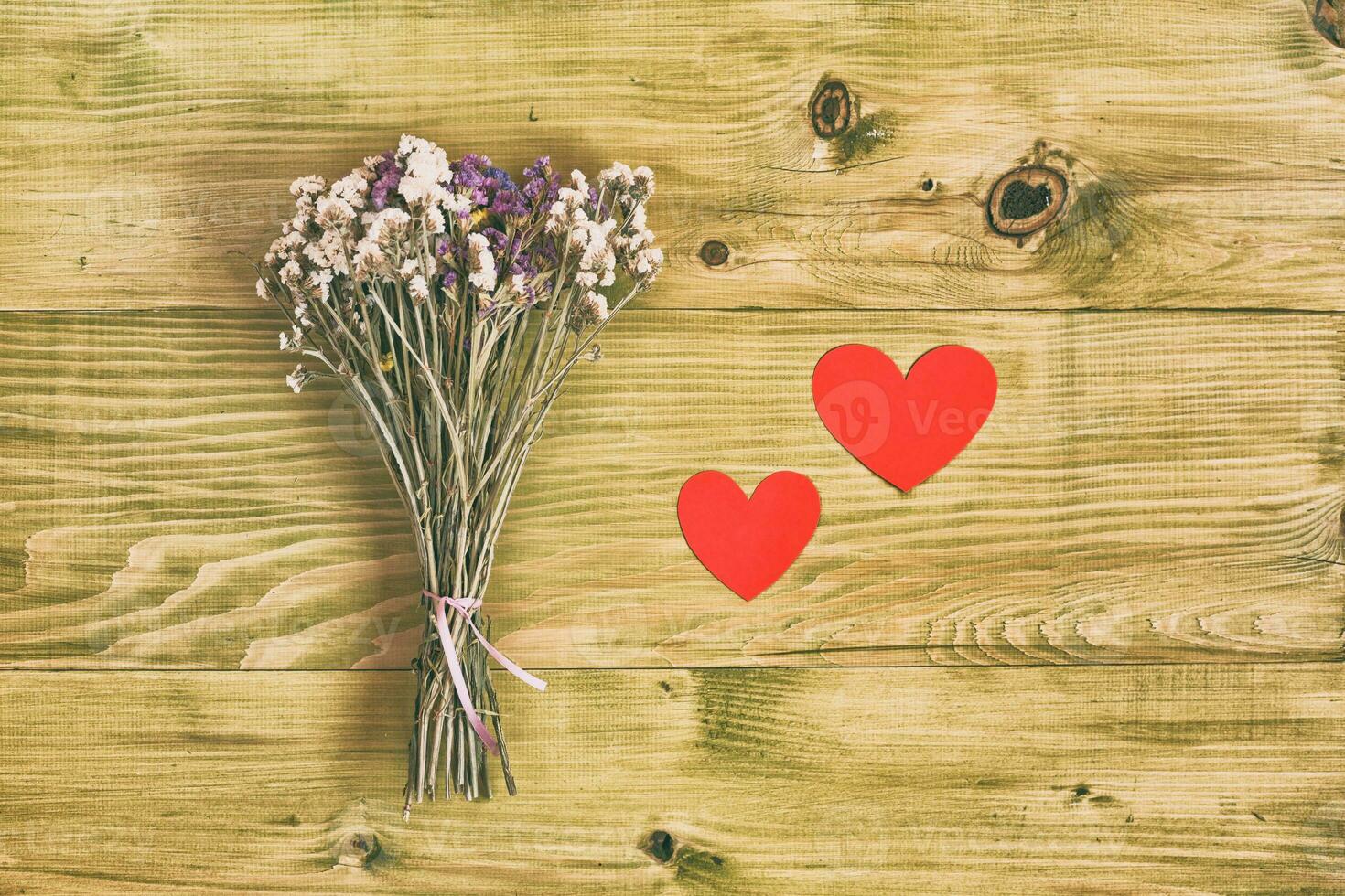 bouquet de fleurs avec cœur formes sur en bois table photo