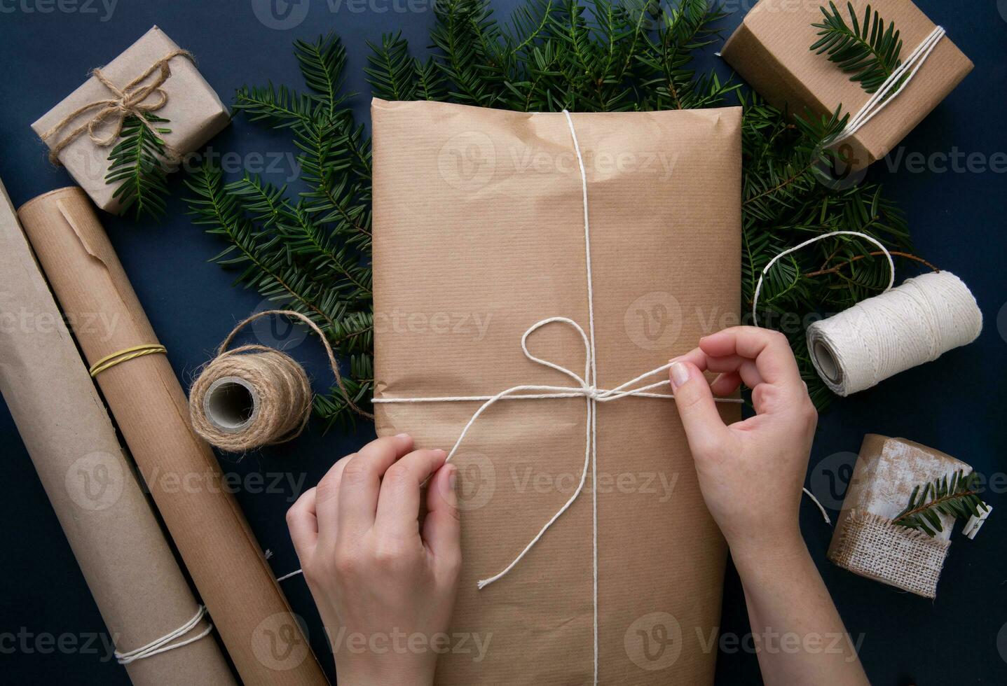 mains attacher une corde sur une paquet avec cadeaux sur le bleu Contexte photo