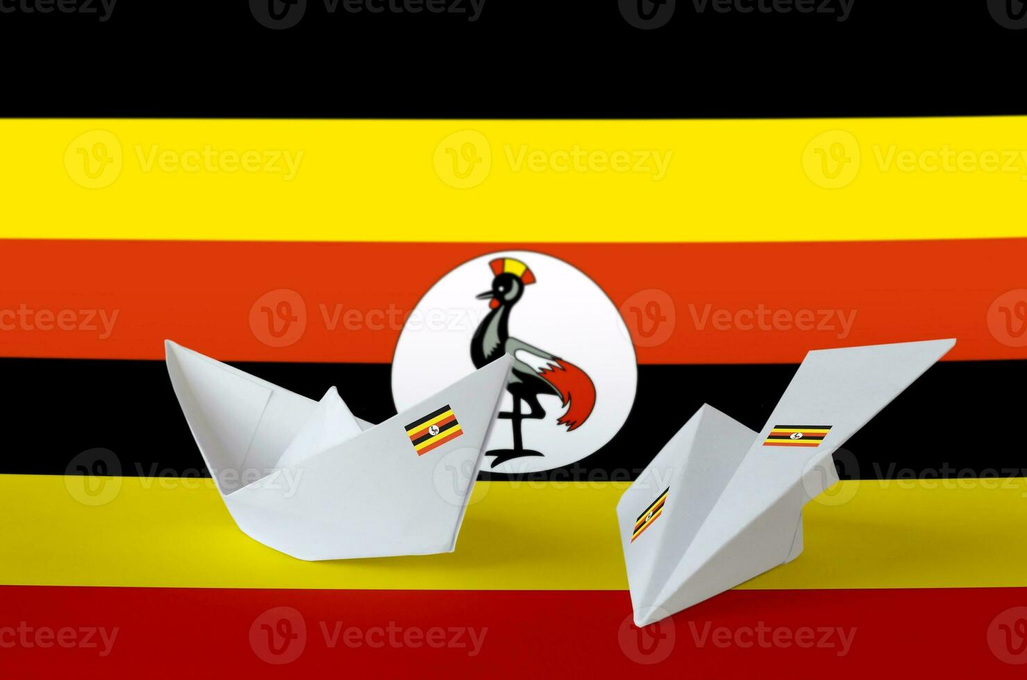 Ouganda drapeau représenté sur papier origami avion et bateau. Fait main les arts concept photo