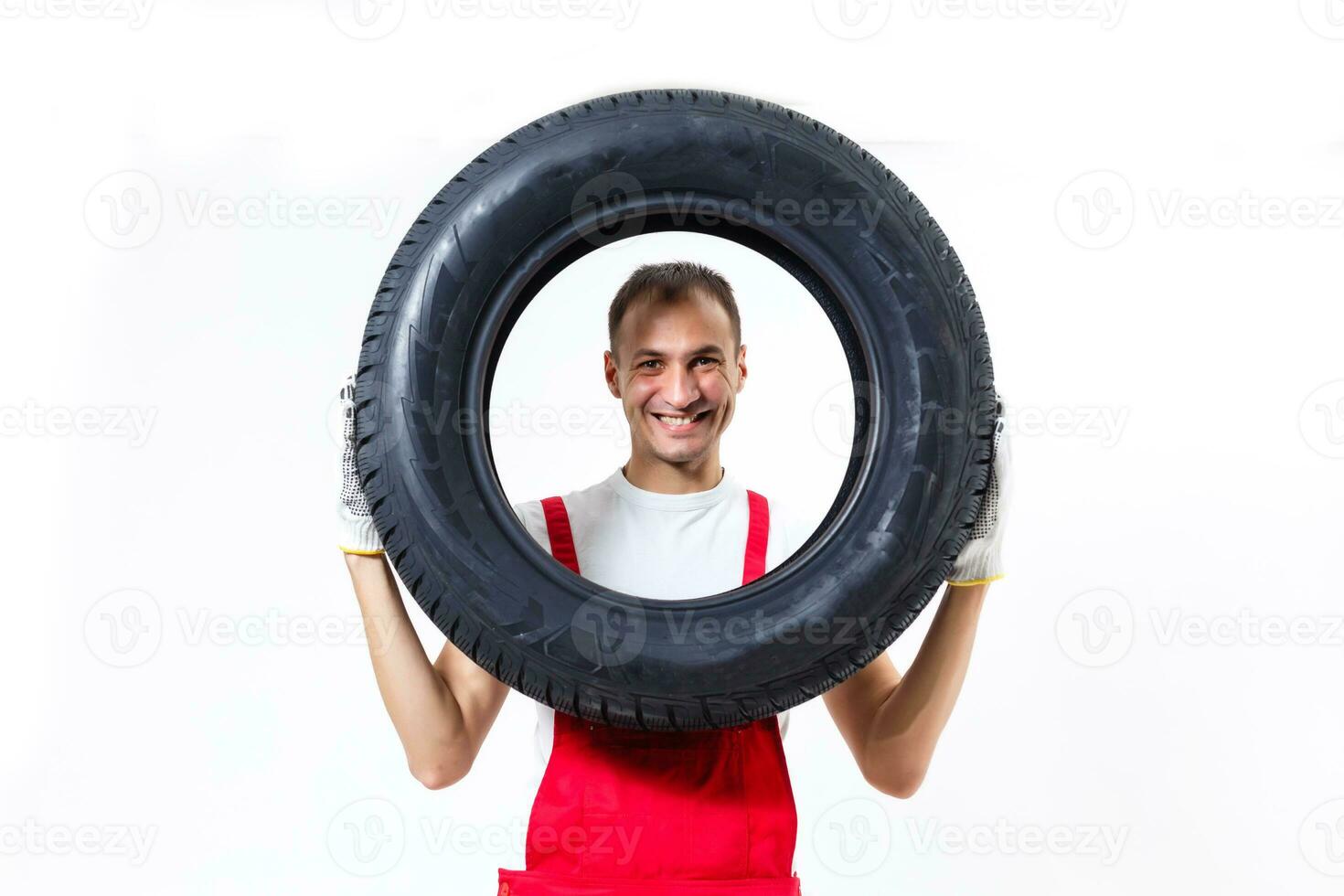 portrait de souriant Masculin mécanicien en portant pneu sur blanc Contexte photo