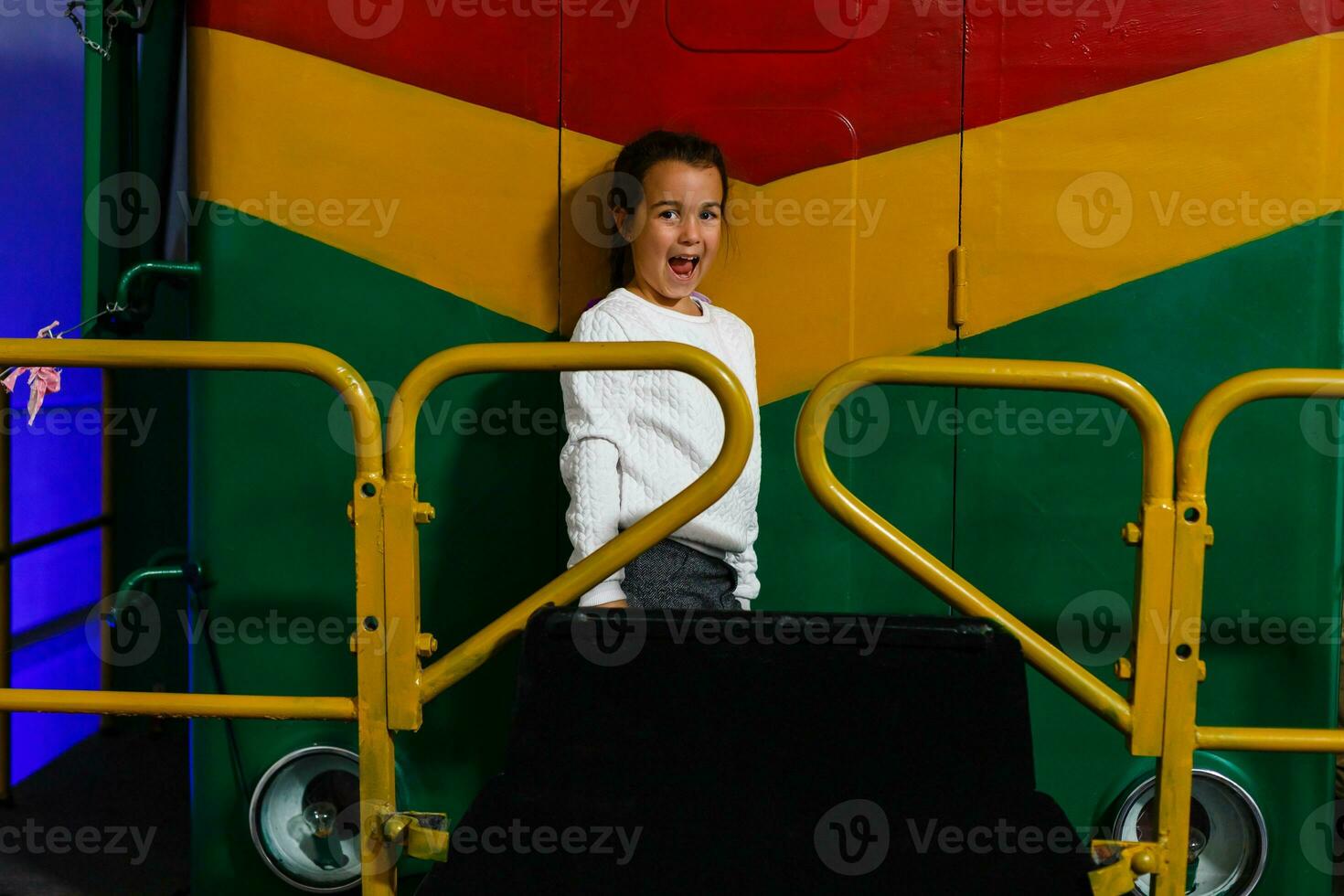 une peu fille des stands suivant à une grand locomotive. photo