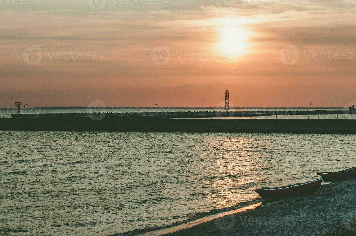 spectaculaire le coucher du soleil sur le plage avec petit bateaux dans Soleil des rayons photo