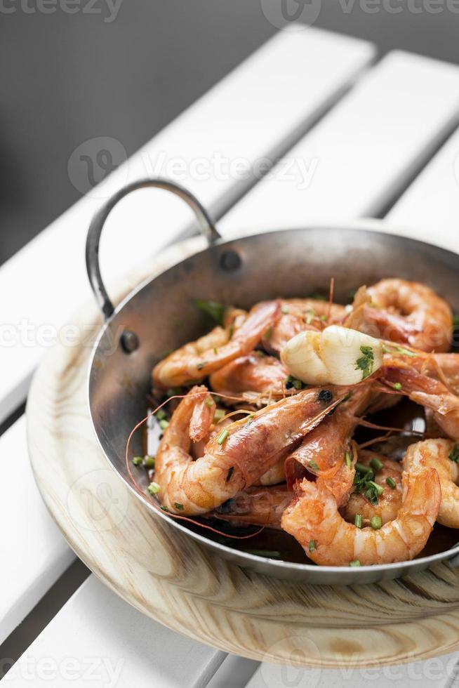 Sauté sauté de grosses crevettes tapas espagnoles dans un pot en métal photo