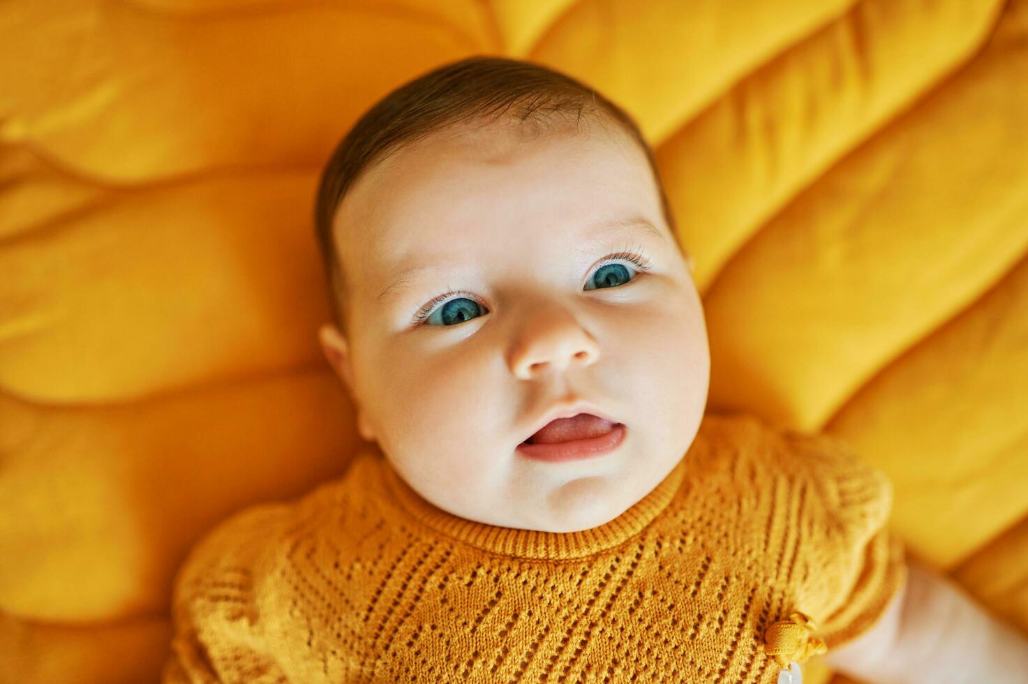 portrait de adorable 6 mois vieux bébé mensonge sur Jaune jouer couverture photo