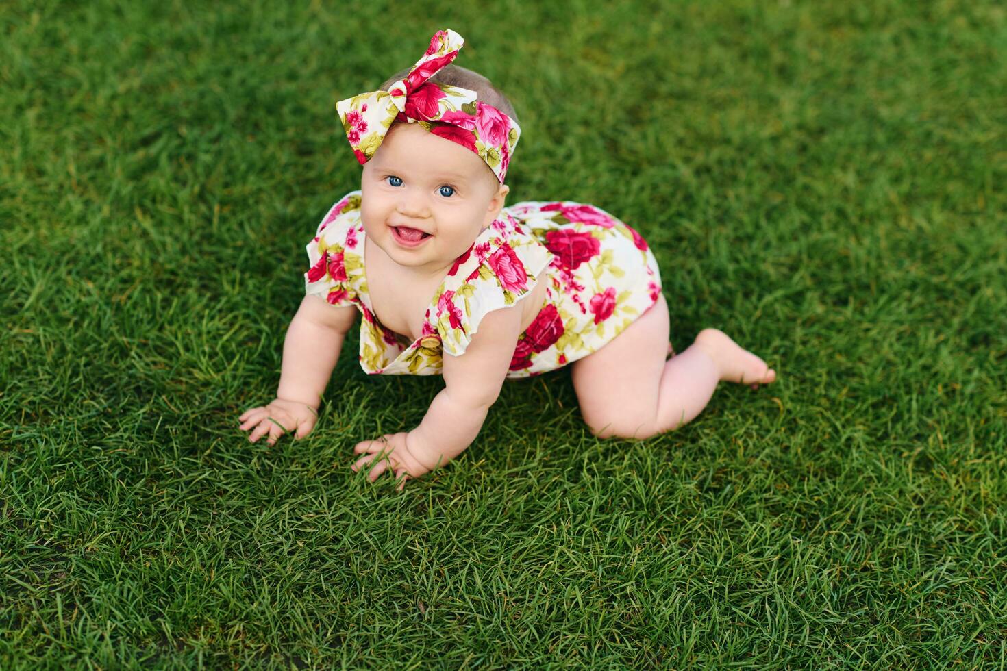 Extérieur portrait de adorable 6 mois vieux bébé fille en jouant dans été parc, enfant rampant sur Frais vert pelouse photo