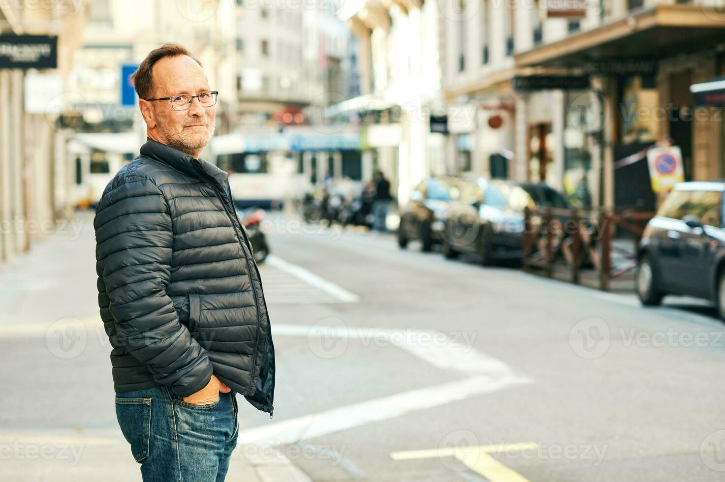 Extérieur portrait de milieu âge homme dans ville, portant bleu veste et lunettes photo