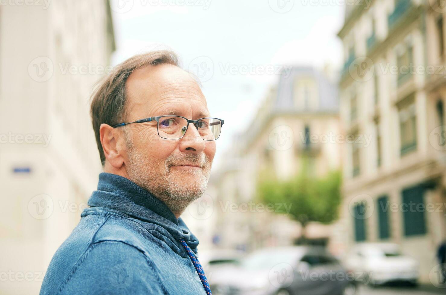 Extérieur portrait de milieu âge homme sur ville rue, portant lunettes photo
