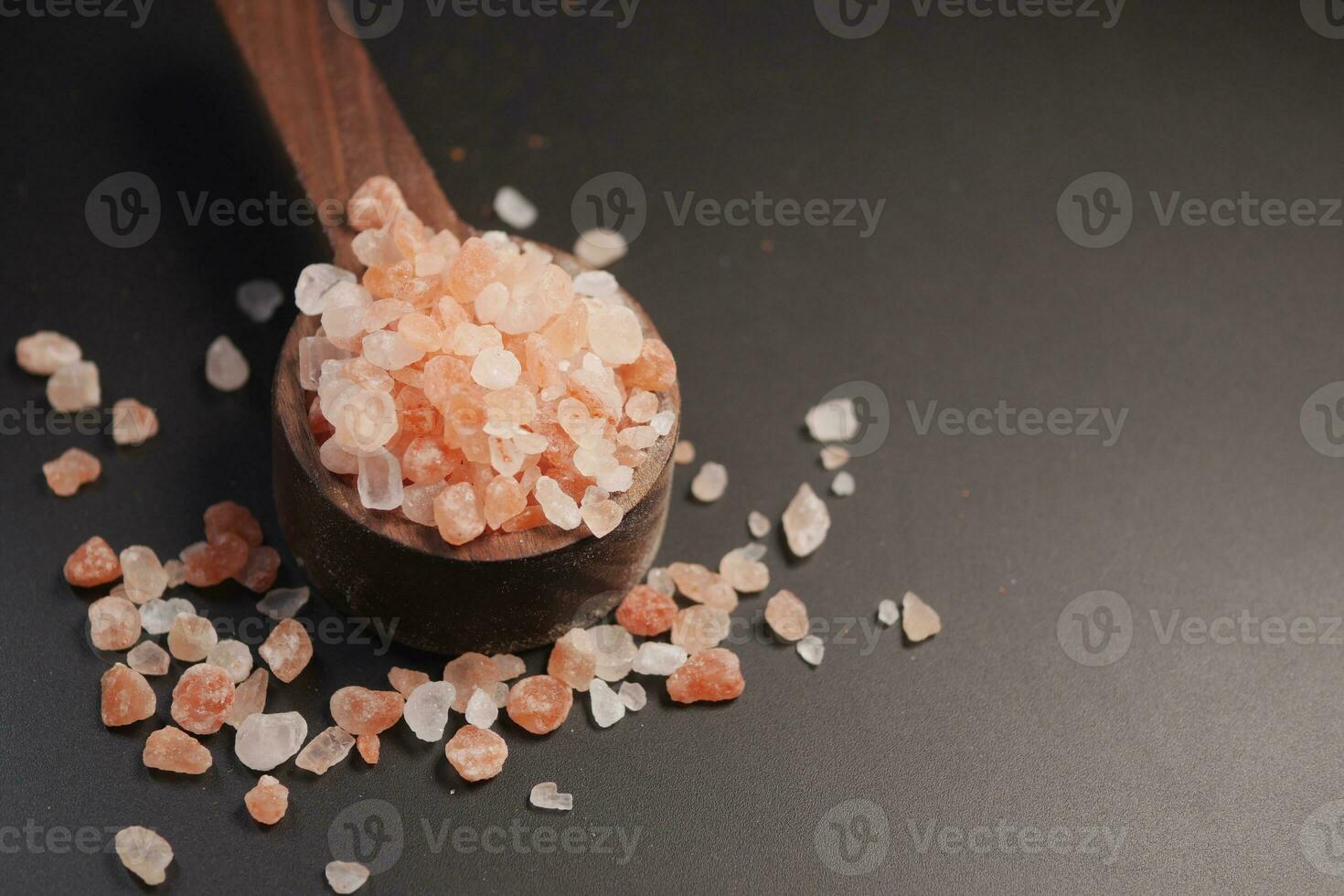 brut séché rose himalayen sel sur en bois cuillère photo