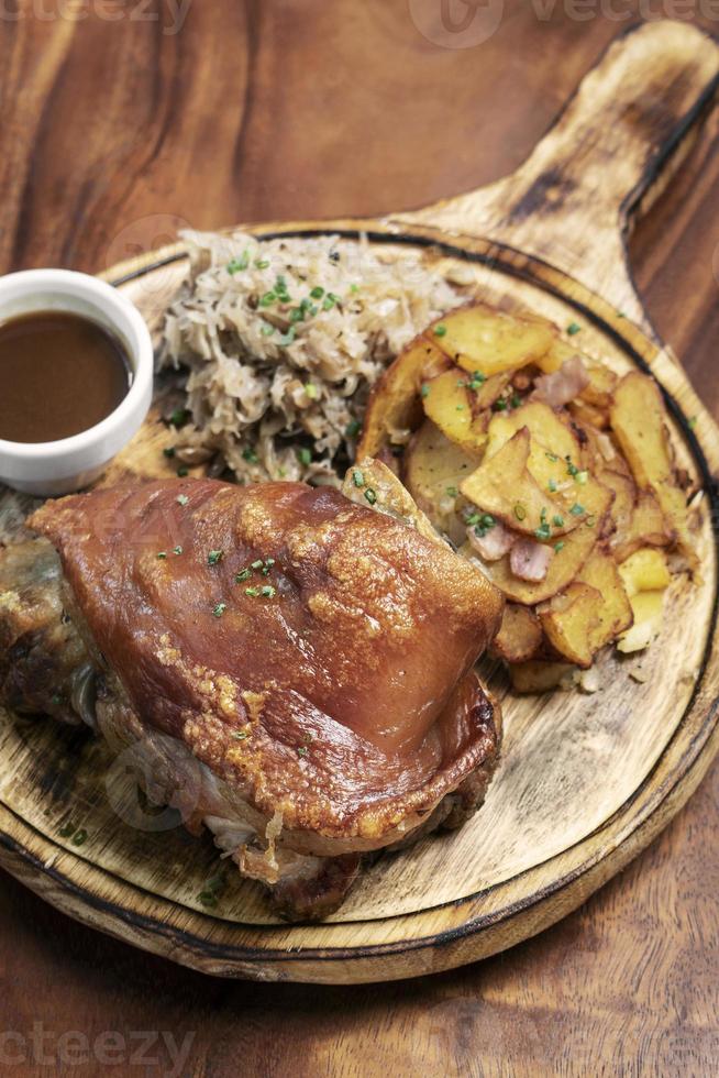 jarret de porc traditionnel allemand schweinshaxe avec choucroute et repas de pommes de terre photo