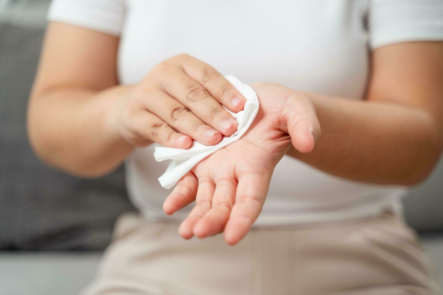 femme lingettes nettoyage sa main avec une tissu papier serviette. soins de santé et médical concept. photo