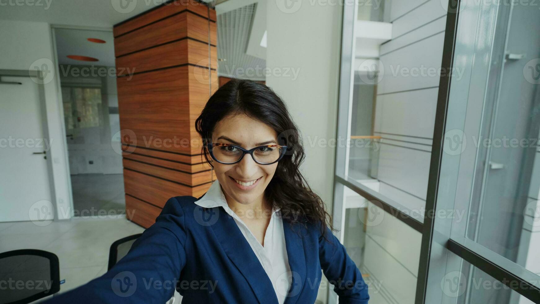 pov de Jeune femme d'affaires dans costume prise une selfie photo en portant téléphone intelligent et avoir amusement dans moderne Bureau à l'intérieur