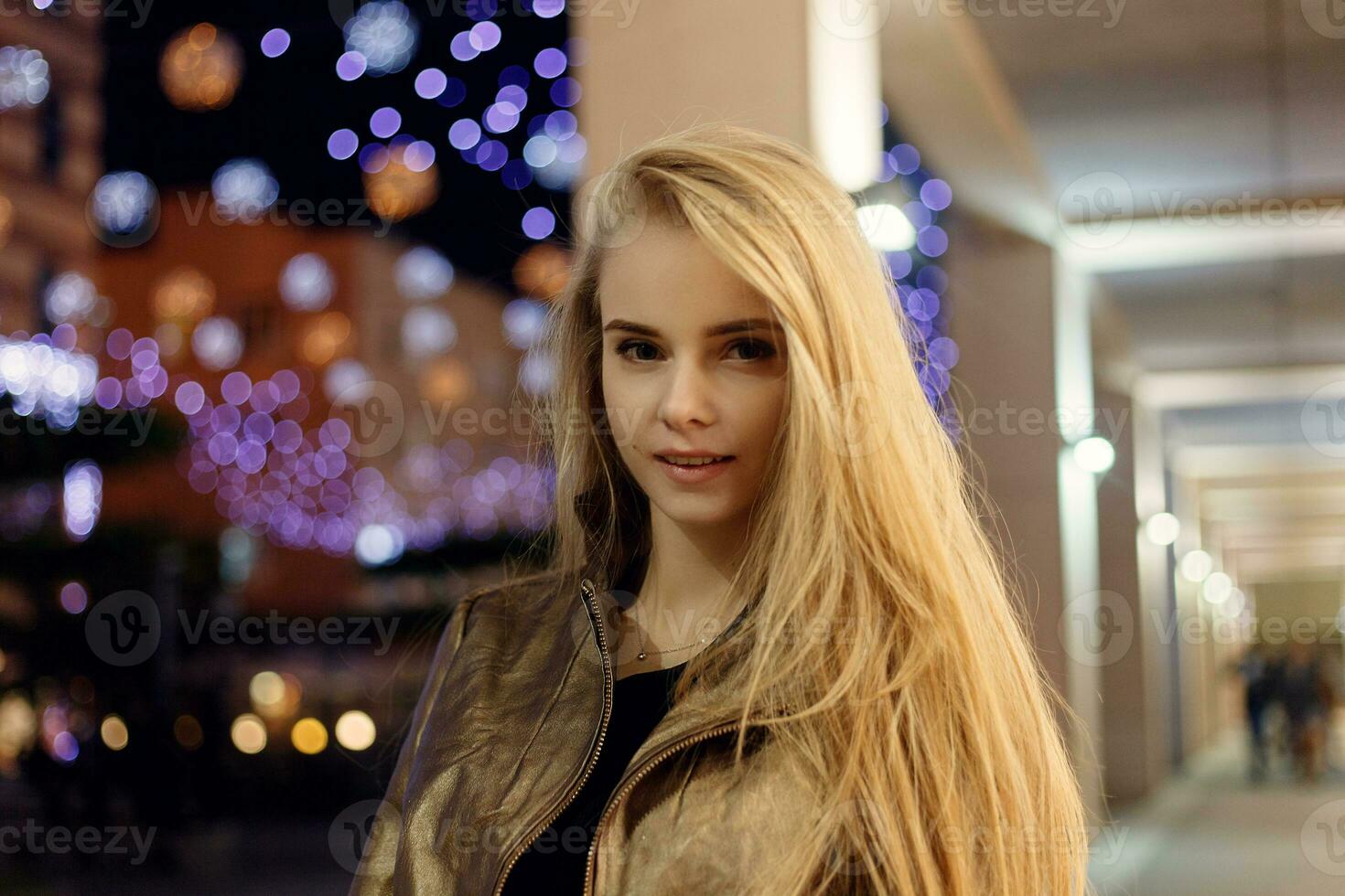 femme souriant dans le nuit contre soir lumières bokeh photo