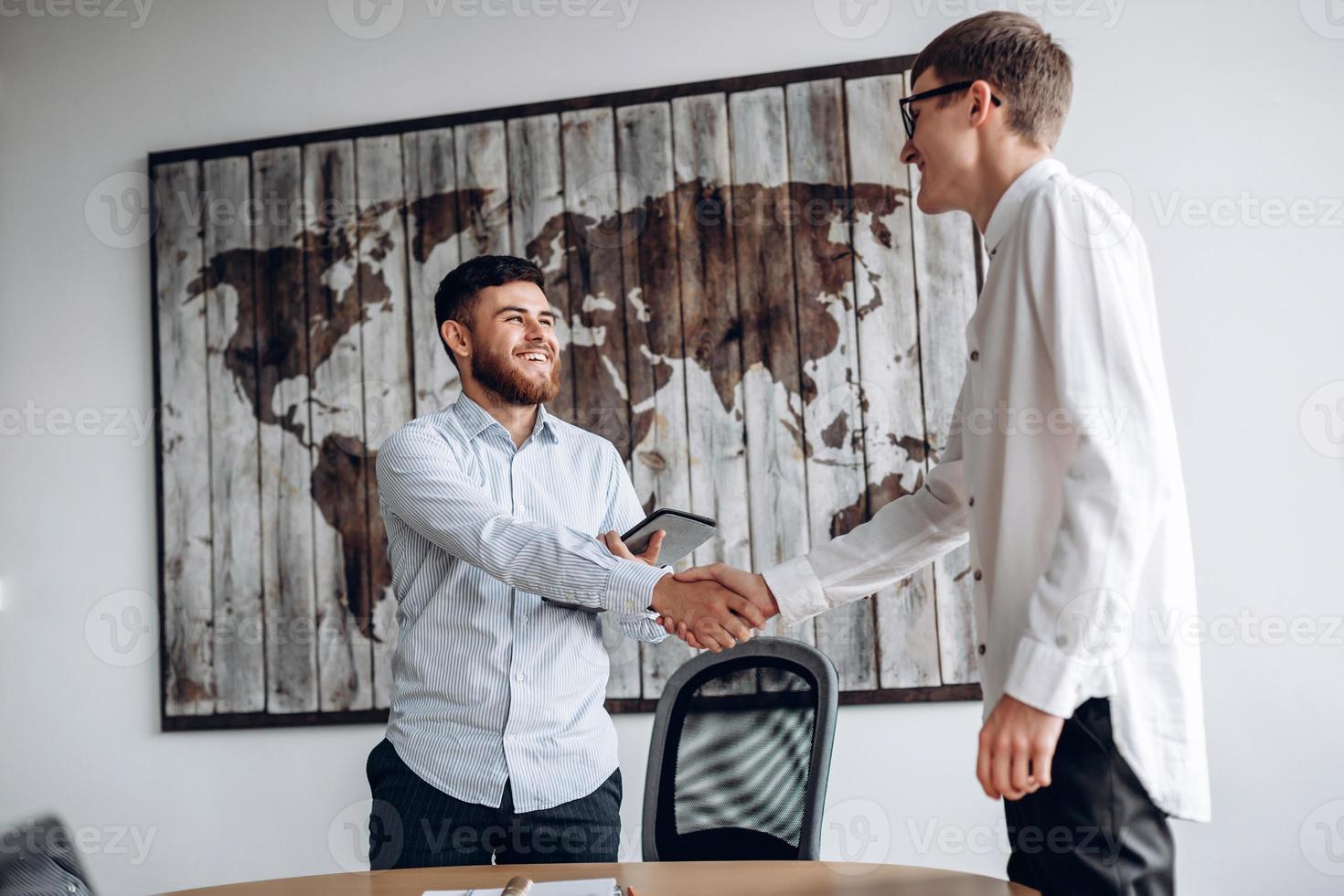 jeune homme souriant serrant la main de son partenaire commercial photo