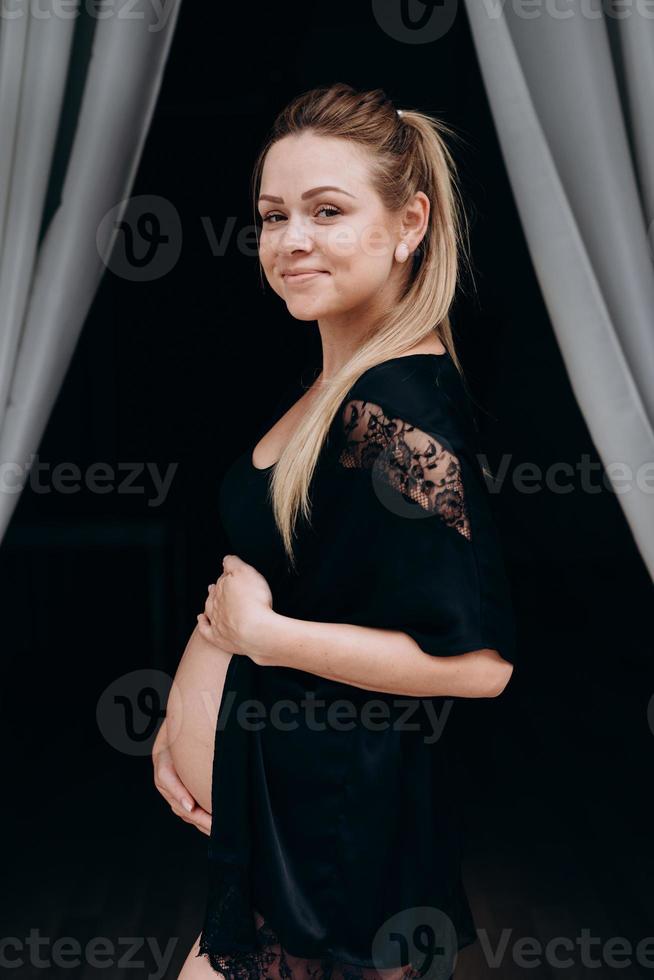 femme enceinte souriante qui pose en studio photo