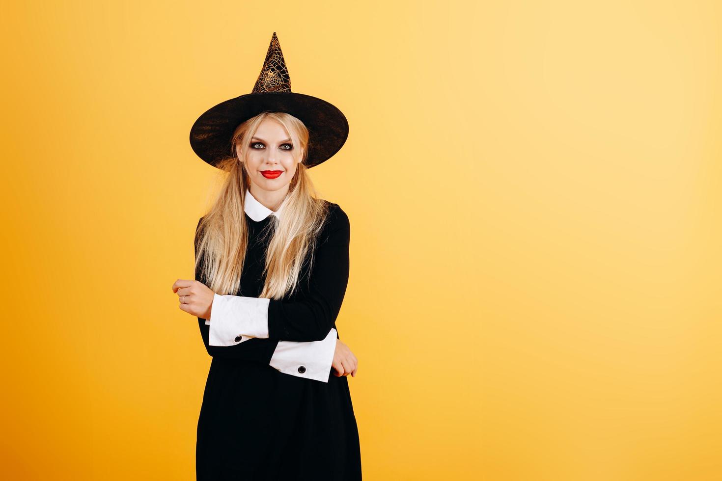 femme en robe de mascarade et chapeau posant sur fond de studio jaune. - image photo