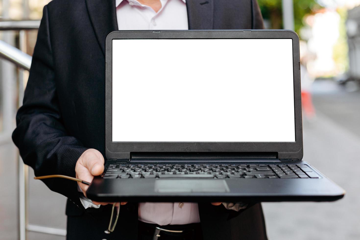Image en gros plan d'un homme d'affaires tenant un ordinateur portable ouvert, écran blanc vide vide- image photo