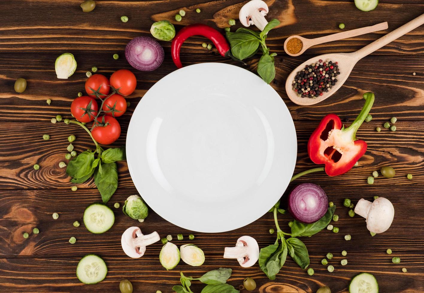 sur une table en bois se trouve une assiette, entourée de produits italiens et d'épices photo