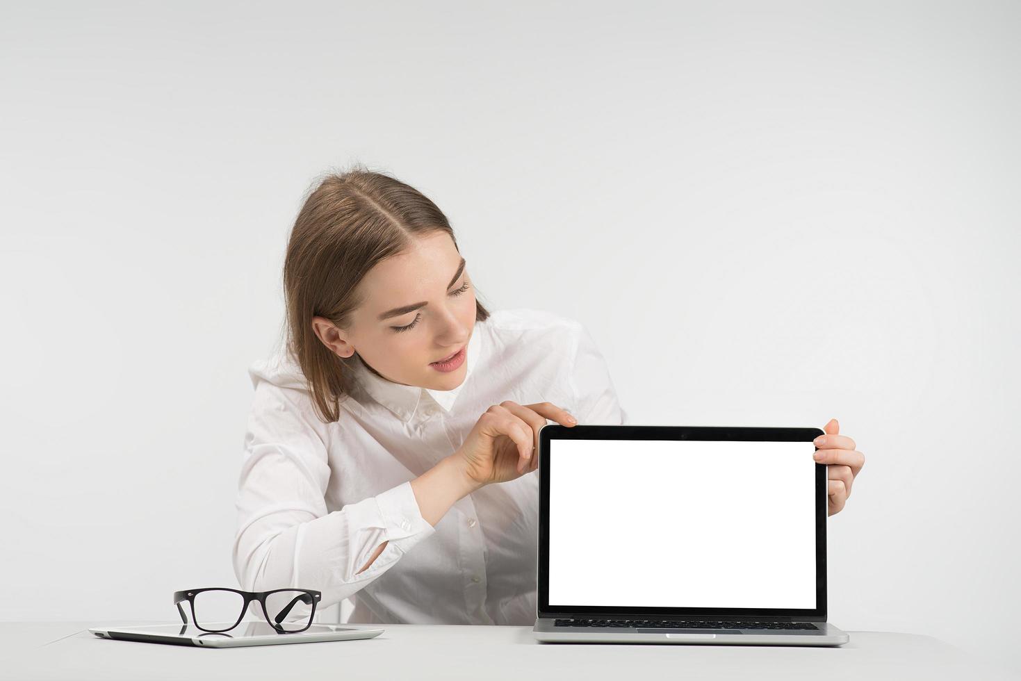 jolie femme est assise à la table et regarde l'écran. concept de maquette photo