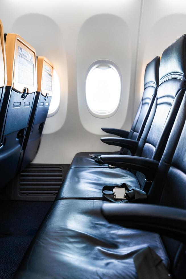 intérieur de l'avion - cabine avec fauteuil en cuir moderne pour passager d'avion. sièges d'avion et hublot. - image verticale photo