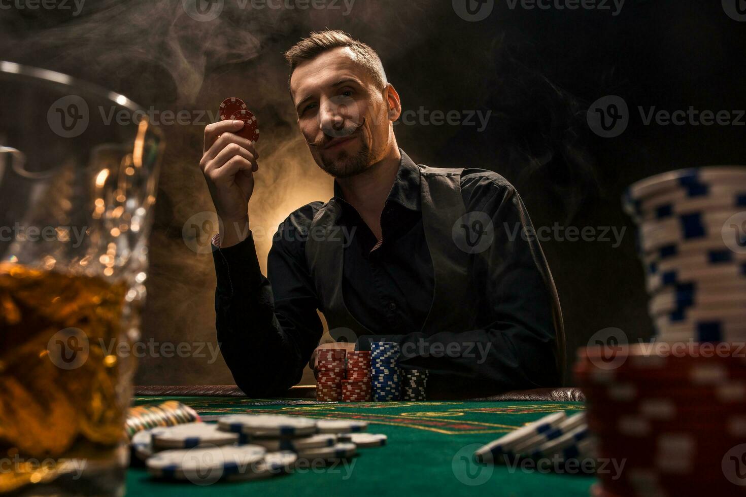 homme est en jouant poker avec une cigare et une whisky. une homme gagnant tout le frites sur le table avec épais cigarette fumée. photo