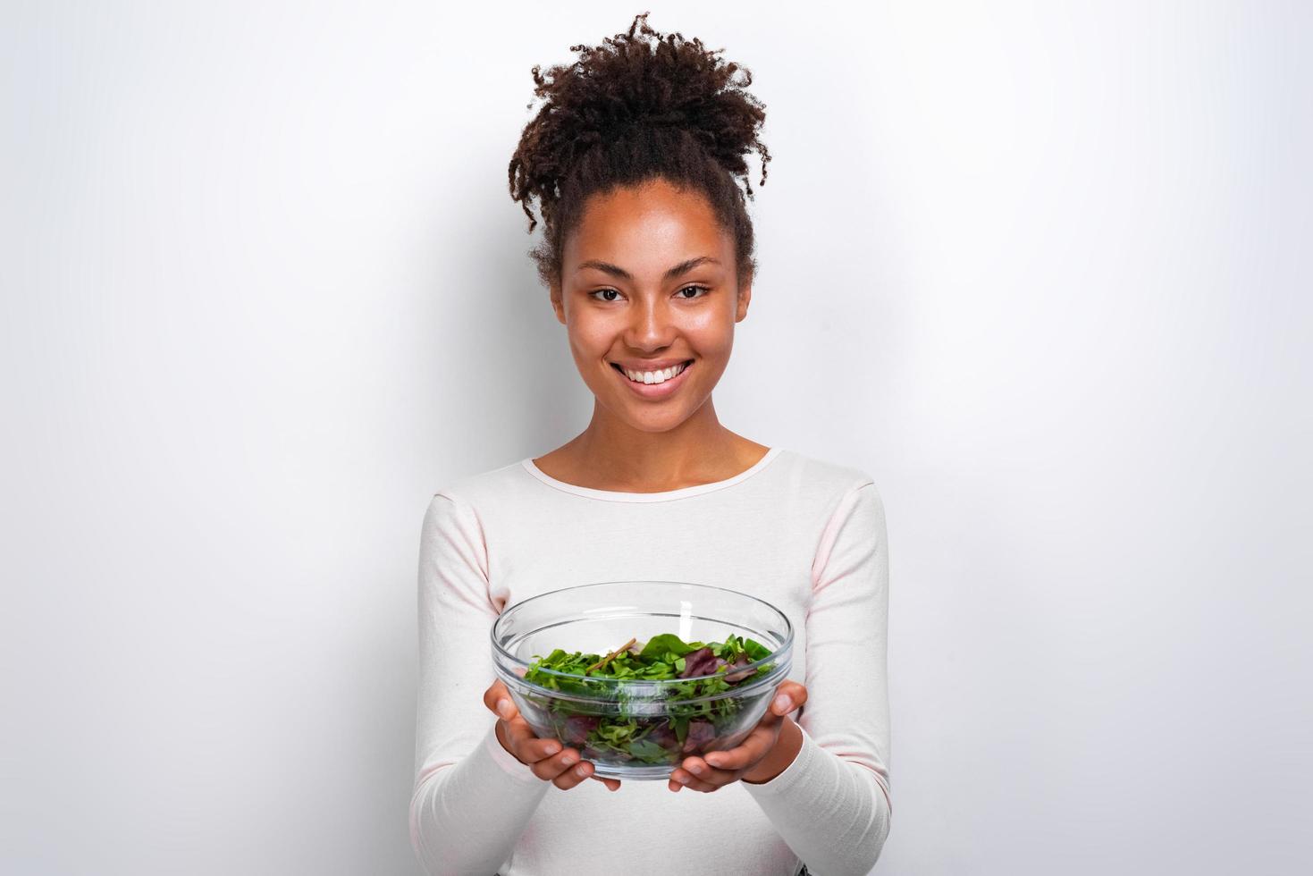 Closeup portrait of woman standing avec bol de salade sur fond wite photo