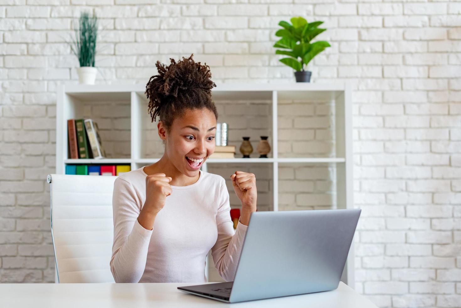 une femme afro-américaine heureuse crie faire un geste gagnant avec les poings fermés photo