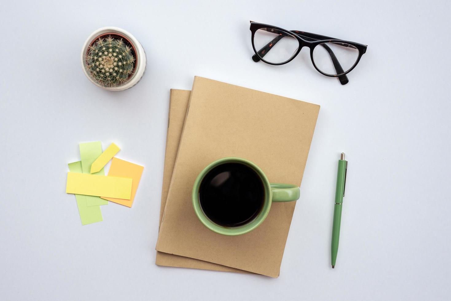 bureau avec verres, tasse de café debout sur un cahier - vue de dessus photo