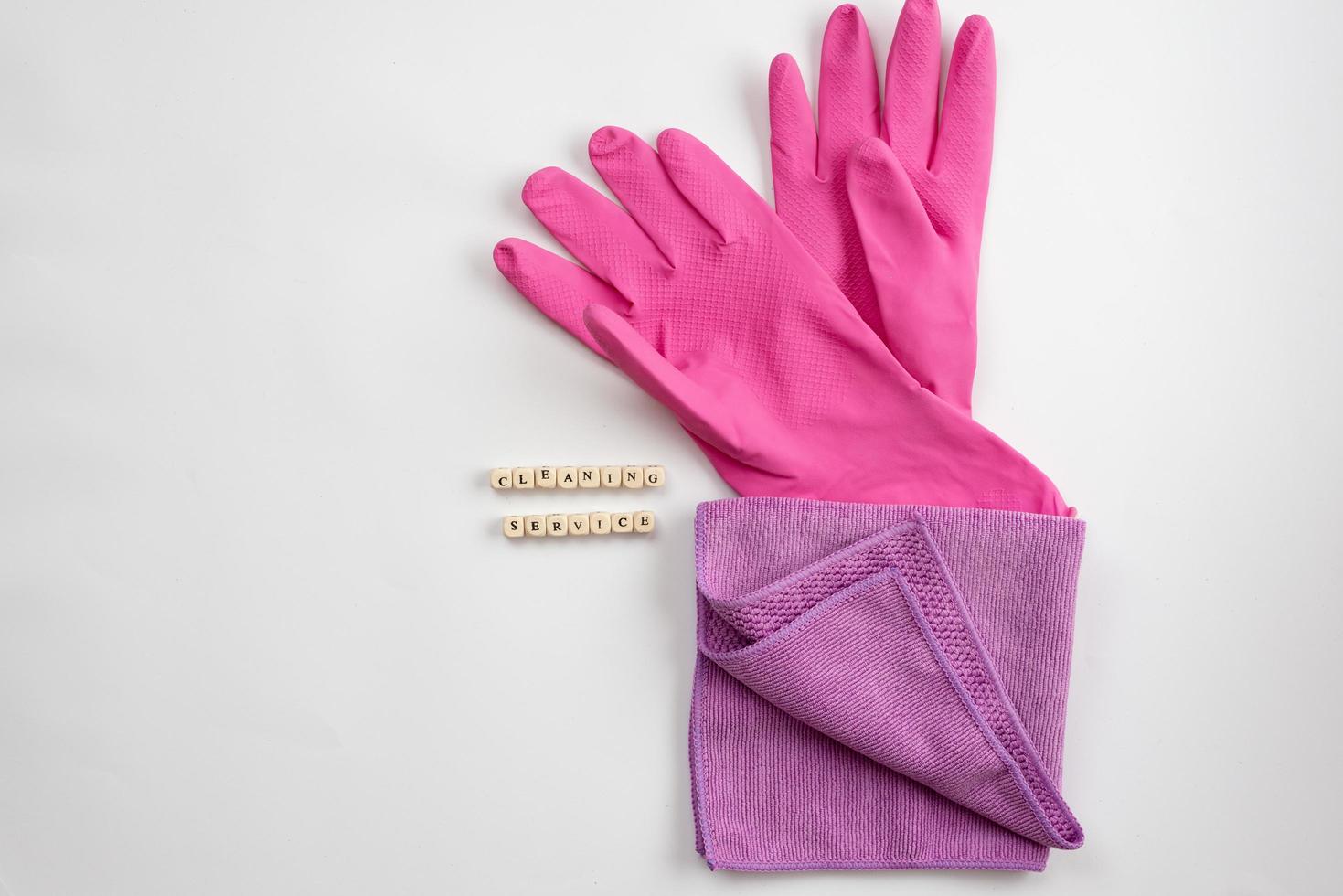 gants en latex rose et chiffon allongé sur un fond blanc. service de nettoyage de concept photo