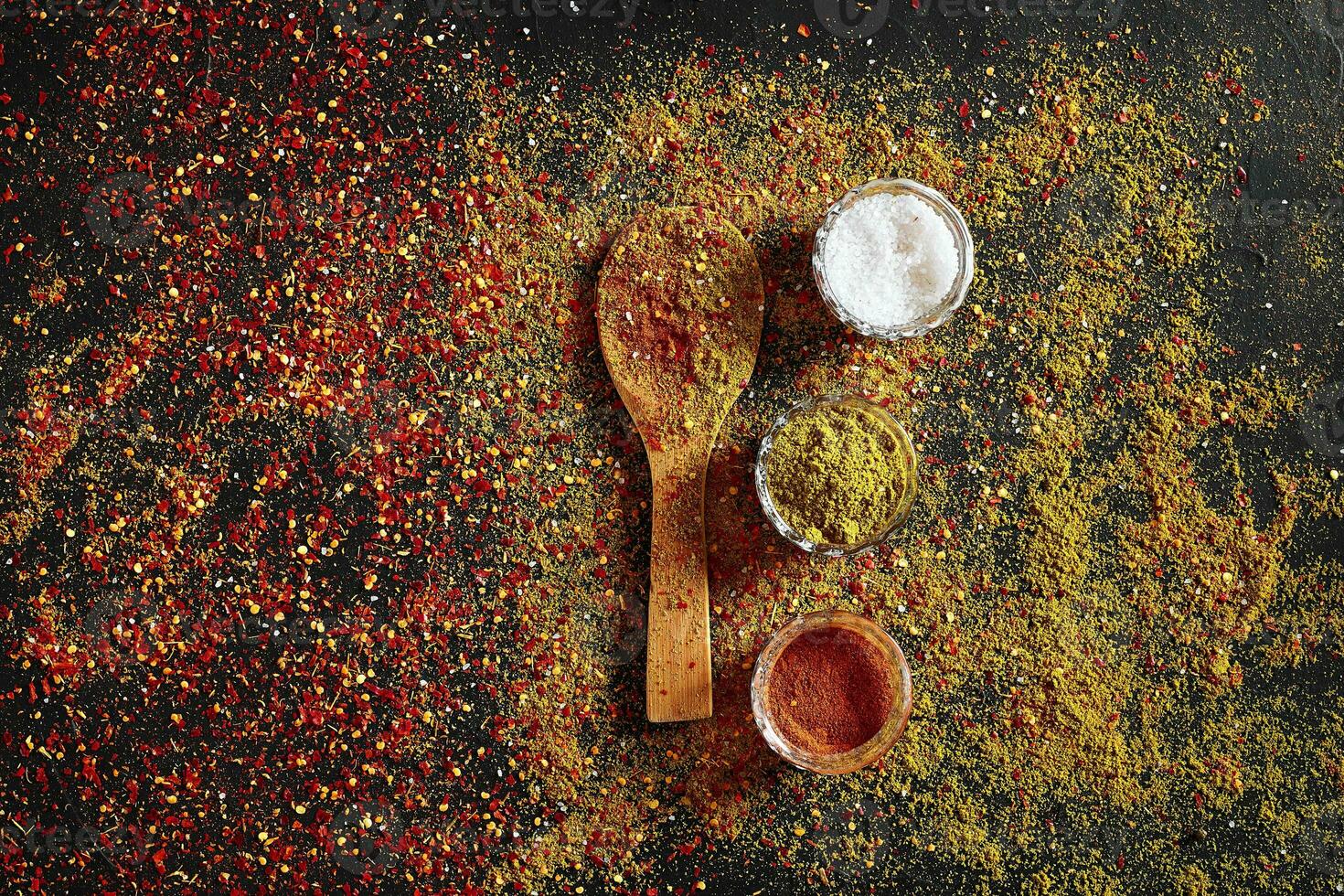 assorti épices sur foncé noir Contexte. assaisonnements pour aliments. curry, paprika, poivre, cardamome, curcuma. Haut voir. photo