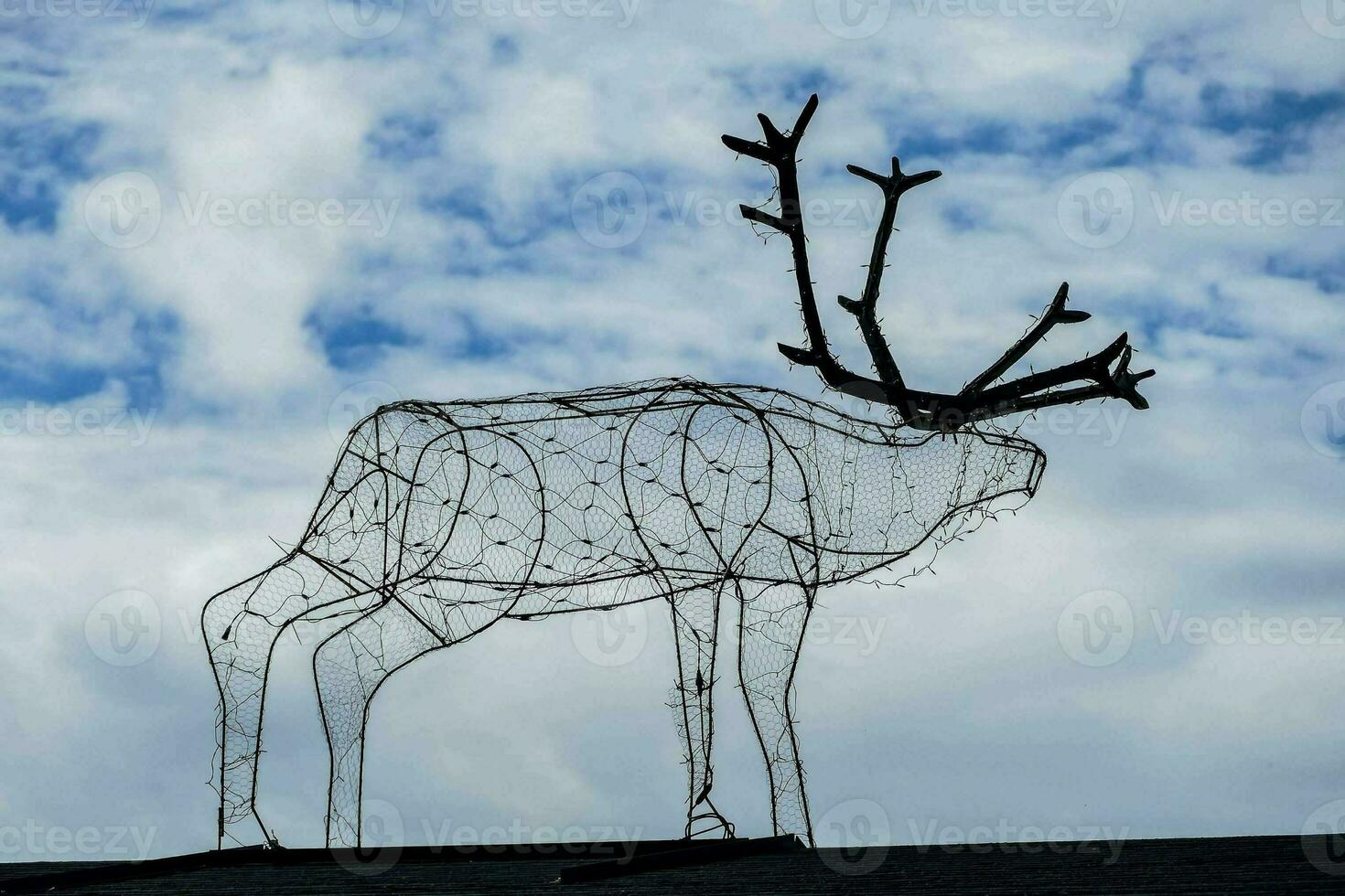 une métal cerf sculpture sur Haut de une toit photo