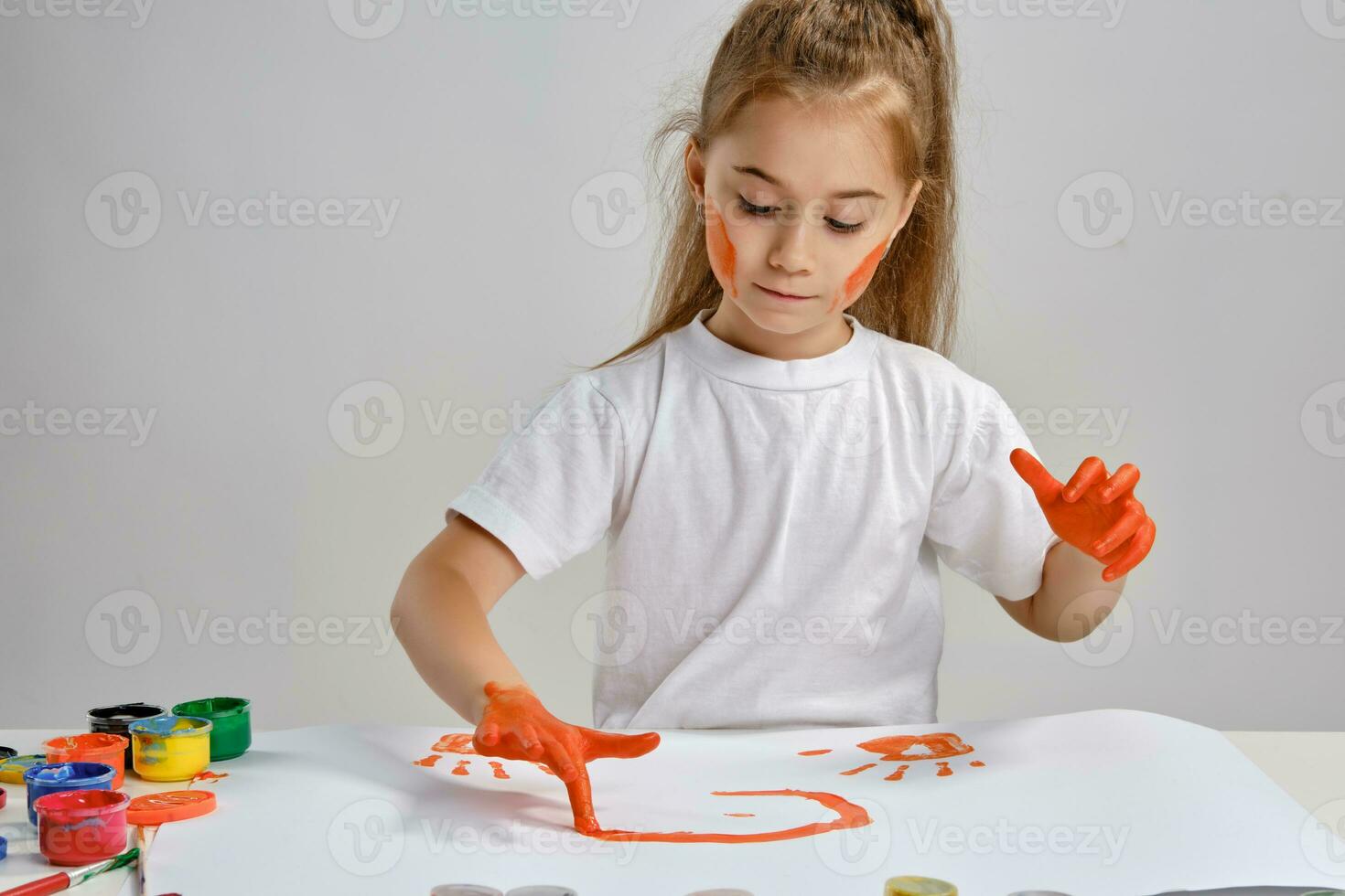 peu fille dans blanc T-shirt séance à table avec Quel homme et coloré des peintures, La peinture sur il avec sa mains. isolé sur blanche. moyen fermer. photo