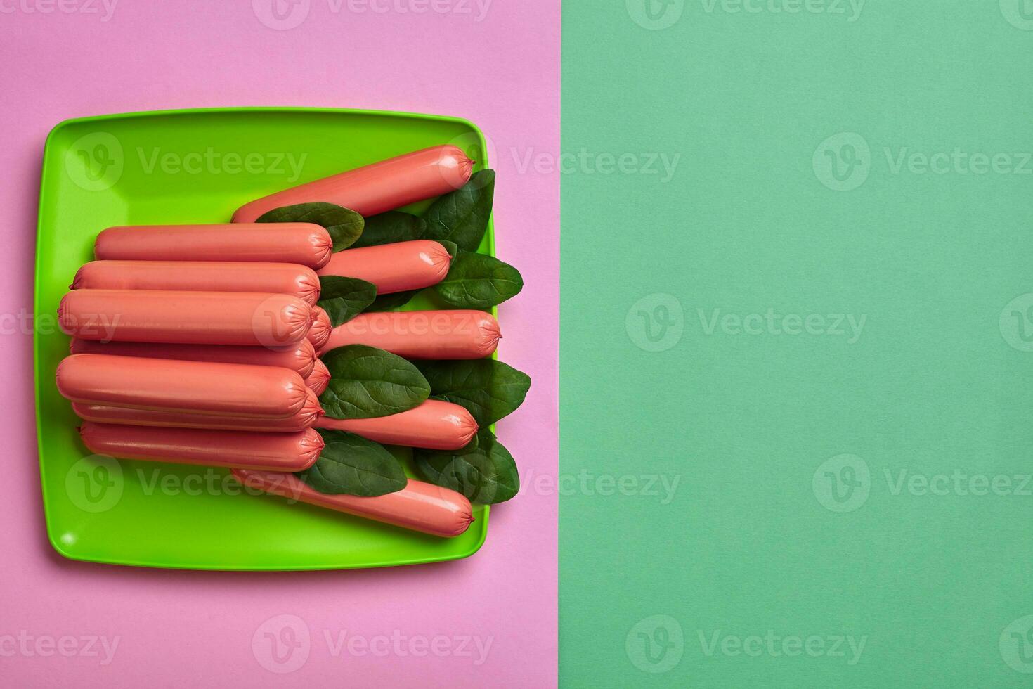 saucisses sur une vert et rose minimal Contexte. plat poser. Haut voir. photo