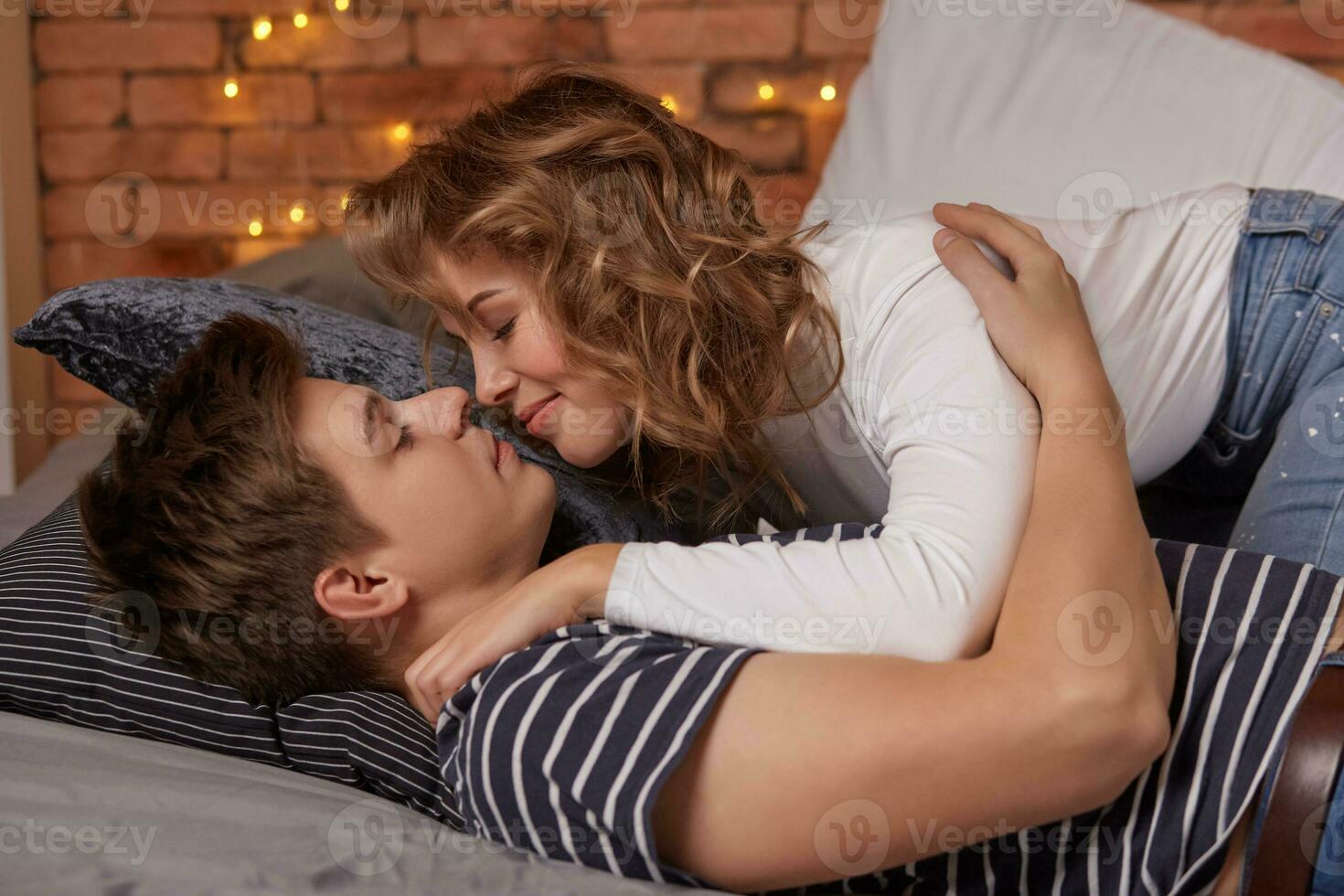 caucasien Jeune magnifique couple mensonge sur lit et étreindre chaque autre photo